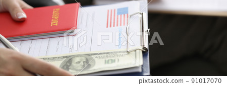 Person sitting in line with visa application forms to get access to enter country 91017070