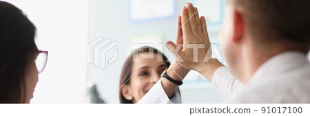 Colleagues give high five after successful agreement with partners Colleagues give high five after successful agreement with partners 91017100