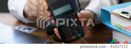 Man holding modern credit card reader machine for cashless payment 91017151