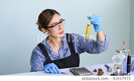 Female biotechnology scientist researching and examining cannabis oil in the laboratory. Herbal alternative medicine, cbd oil concept 91017472