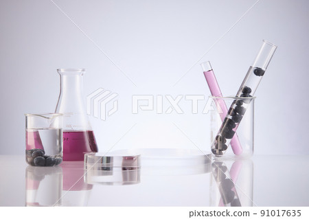 Front view of blueberry extract decorated with transparent podium and glassware blank space in white background Front view of blueberry extract decorated with transparent podium and glassware blank space in white background 91017635