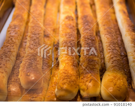 Close-up view of the chesse stick breads on a tray and selling in the bakery shop. Close-up view of the chesse stick breads on a tray and selling in the bakery shop. 91018140