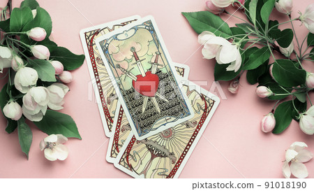 Blurred Tarot cards three of swords pink still Life on table. Esoteric concept and astrology 91018190