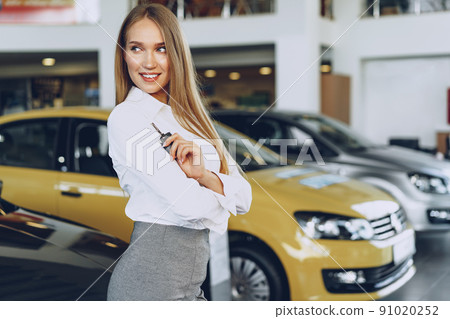 Young happy woman buyer/seller near the car with keys in hand Young happy woman buyer/seller near the car with keys in hand 91020252