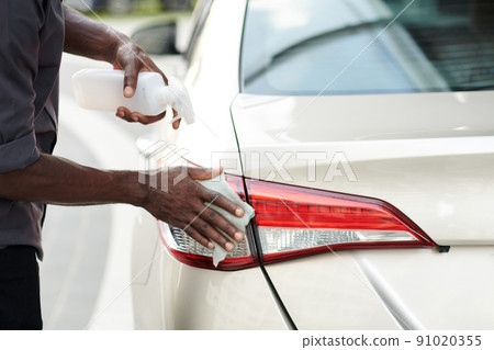 Car Owner Cleaning Back Lights Car Owner Cleaning Back Lights 91020355