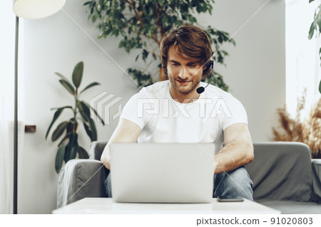 Young man businessman with headset working on laptop from home 91020803