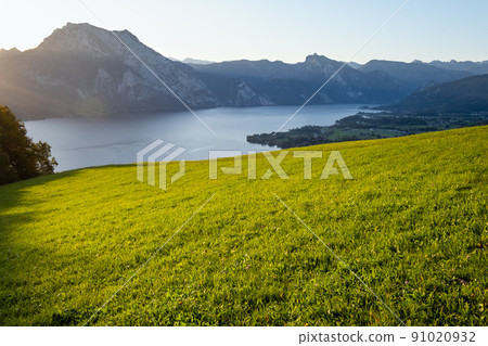 Peaceful autumn Alps mountain lake. Sunrise view to Traunsee lake, Gmundnerberg, Altmunster am Traunsee, Upper Austria. 91020932