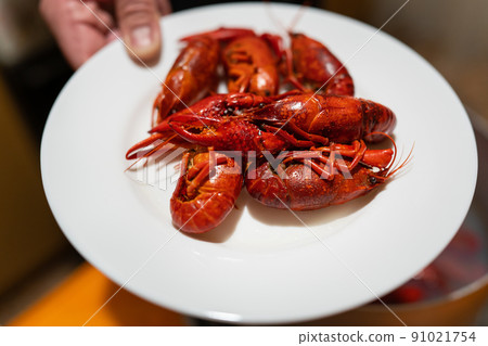 Red fresh appetizing crayfish on a white plate. Delicious food for beer. 91021754