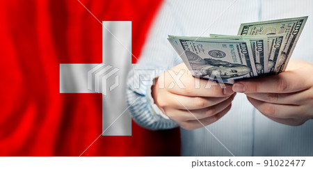 Swiss flag and American dollars cash money in hand.  91022477