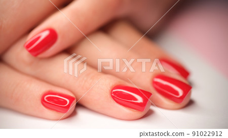 Woman hands with perfect bright red glossy manicure 91022912