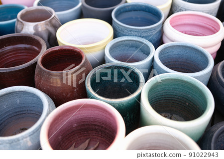 Empty colourful ceramic flower pots in greenhouse or hothouse Empty colourful ceramic flower pots in greenhouse or hothouse 91022943