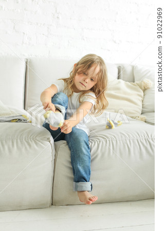 Cute child girl putting on a sock at home Cute child girl putting on a sock at home 91022969