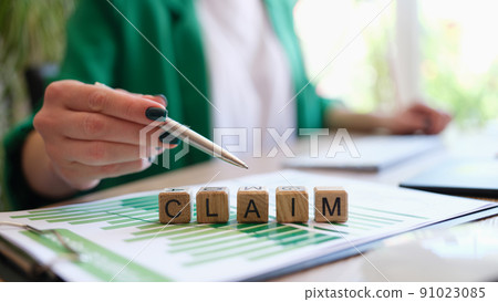 Woman pointing with pen on word claim made with wooden cubes in row Woman pointing with pen on word claim made with wooden cubes in row 91023085
