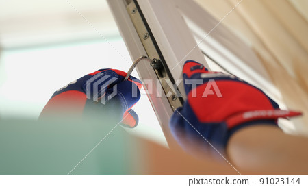 Male hands in gloves adjusting locks of pvc windows with special key Male hands in gloves adjusting locks of pvc windows with special key 91023144