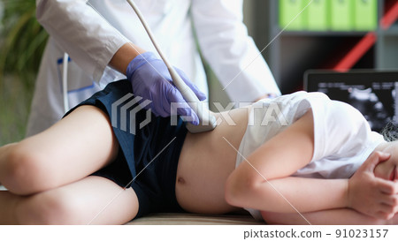Ultrasound specialist examining little kid in clinic office Ultrasound specialist examining little kid in clinic office 91023157