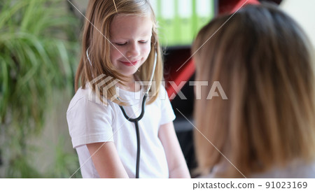 Smiling little kid testing medical stethoscope at doctor appointment Smiling little kid testing medical stethoscope at doctor appointment 91023169