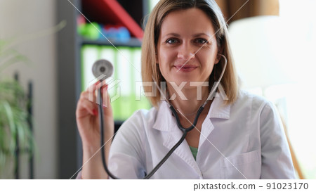 Happy smiling female practitioner showing medical stethoscope Happy smiling female practitioner showing medical stethoscope 91023170