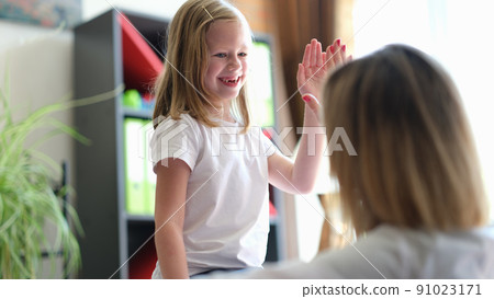 Smiling kid giving five to female pediatrician Smiling kid giving five to female pediatrician 91023171