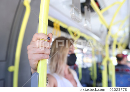Woman hand holding handrail in tram or bus 91023778