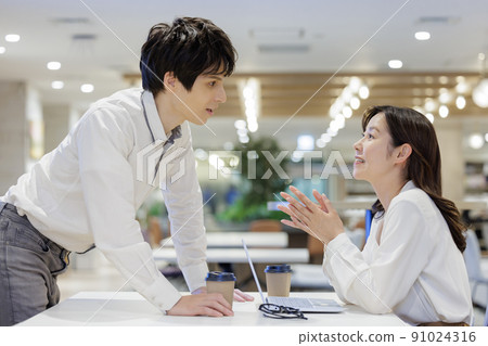 Men and women chatting in the office conversation 91024316