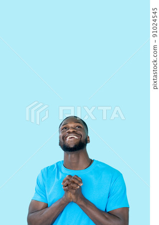 Thankful emotion. Pleading expression. Advertising flyer. Hopeful happy grateful praying man isolated on blue empty space background. Thankful emotion. Pleading expression. Advertising flyer. Hopeful happy grateful praying man isolated on blue empty space background. 91024545