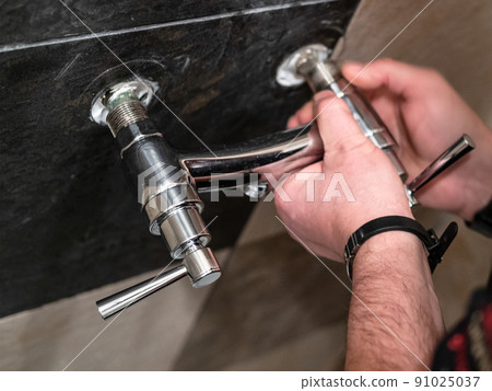 plumber adjusts eccentrics of shower faucet valve 91025037