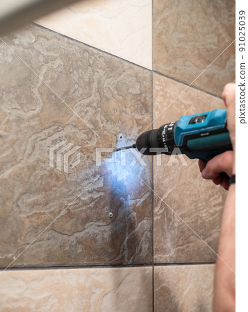 repairer drilling wall tiles with electric drill repairer drilling wall tiles with electric drill 91025039