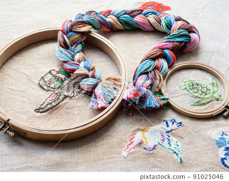 threads woven into braid and wooden hoops close up 91025046