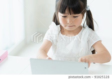 Girl learning while looking at a tablet 91025128