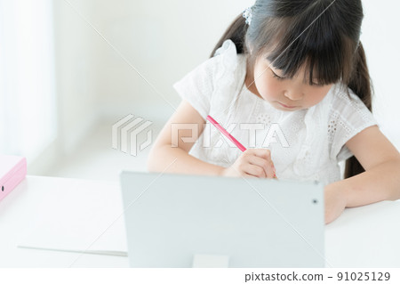 Girl learning while looking at a tablet 91025129