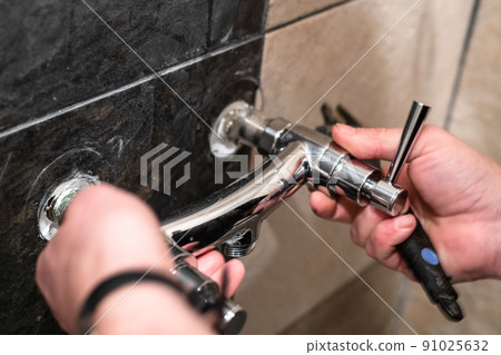 plumber installs new shower faucet valve on wall plumber installs new shower faucet valve on wall 91025632