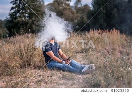 Handsome vape man blows up a couple an e-cigarette. Electronic cigarette as alternative to tobacco. Handsome vape man blows up a couple an e-cigarette. Electronic cigarette as alternative to tobacco. 91025830