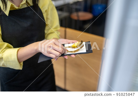 Womans hands holding cutlery in napkin 91025847