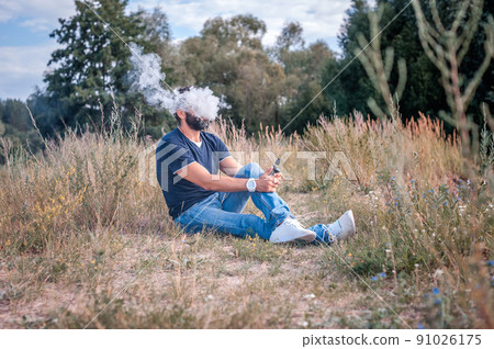Confident vape man blows up a couple an electronic cigarette. Electronic cigarette as alternative to tobacco. Confident vape man blows up a couple an electronic cigarette. Electronic cigarette as alternative to tobacco. 91026175