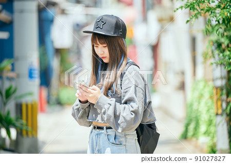Gen Z women operating smartphones 91027827