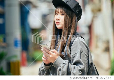 Gen Z women operating smartphones 91027842
