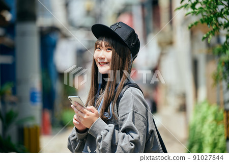 Gen Z women operating smartphones 91027844