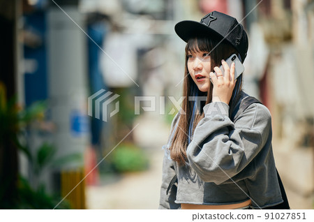 Gen Z women making phone calls on their smartphones 91027851