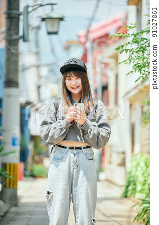Gen Z women staring at you with your smartphone 91027861