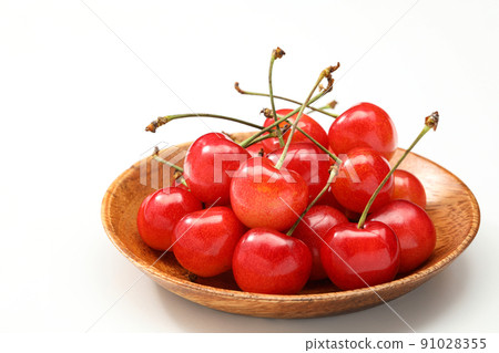 Cherry served on a wooden plate with a white background 91028355
