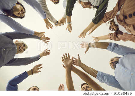 View from below of team of business people standing together and joining their hands 91028459
