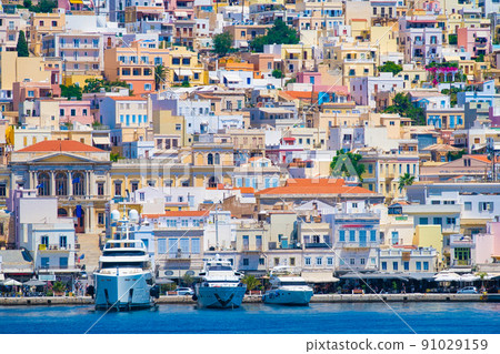 Ermoupolis, Greece. A town on the side of a mountain. Houses and streets in Greek architecture. Ermoupolis, Greece. A town on the side of a mountain. Houses and streets in Greek architecture. 91029159