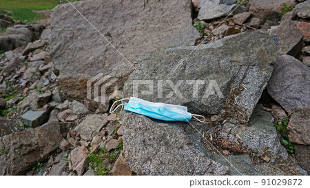 The used medical mask was thrown out in nature. The used medical mask was thrown out in nature. 91029872