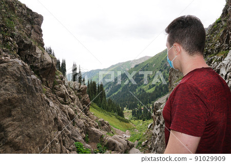 Guy in the mountains takes off his medical mask. Guy in the mountains takes off his medical mask. 91029909