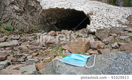 The used medical mask was thrown out in nature. 91029913