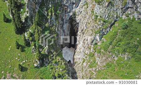 Top view of steep mountain cliffs and an ice cave. Top view of steep mountain cliffs and an ice cave. 91030081