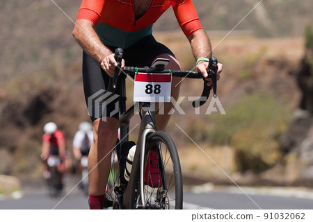 Cycling competition,cyclist athletes riding a race, climbing up a hill on a bicycle 91032062