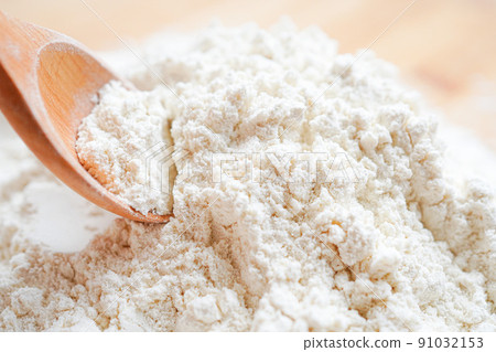 Place the flour on the table with a wooden spoon Place the flour on the table with a wooden spoon 91032153