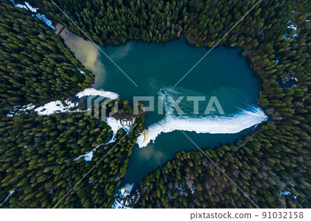 Synevyr lake in the Carpathians, top view of the lake, mountain lake covered with ice, ice line on Synevyr lake. Synevyr lake in the Carpathians, top view of the lake, mountain lake covered with ice, ice line on Synevyr lake. 91032158