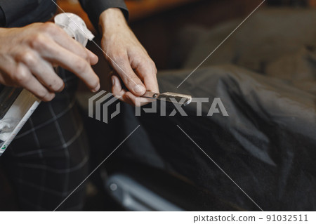 Barbershop. Close-up of barber holds razor for shaving his beard 91032511